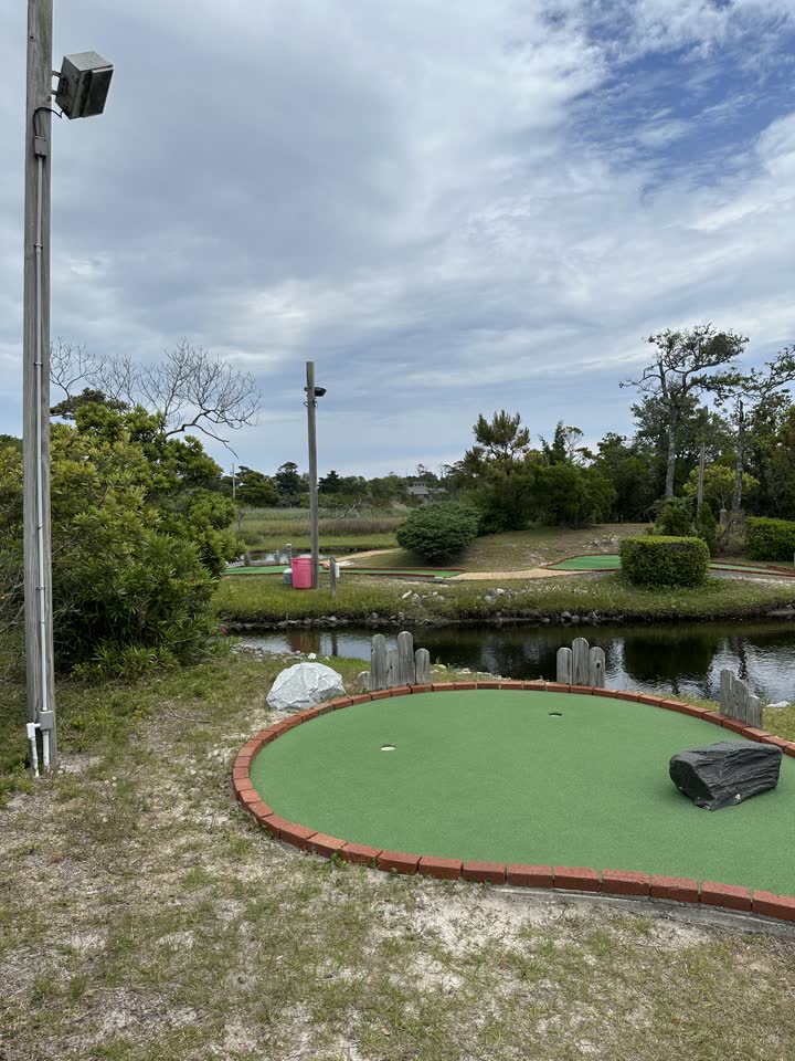 Mini golf green beside the pond under Outer Banks sky